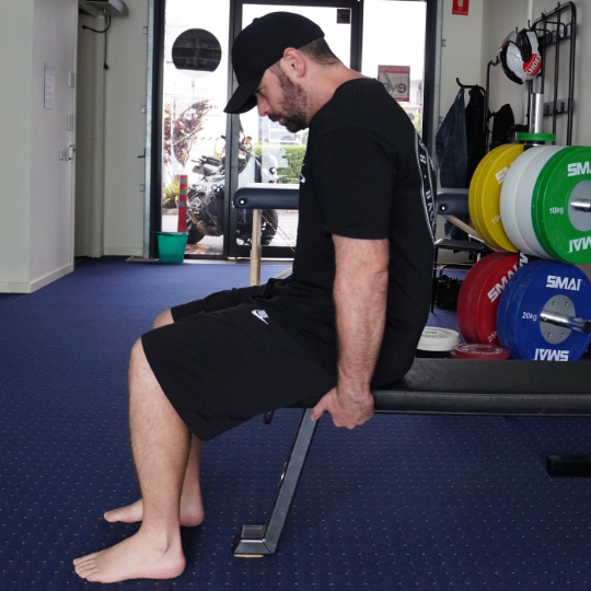 The slumped position of the slump test with upper and lower back rounded into flexion.