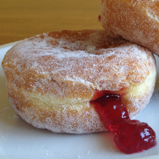 A squashed jam doughnut with jam leaking out of the rear.